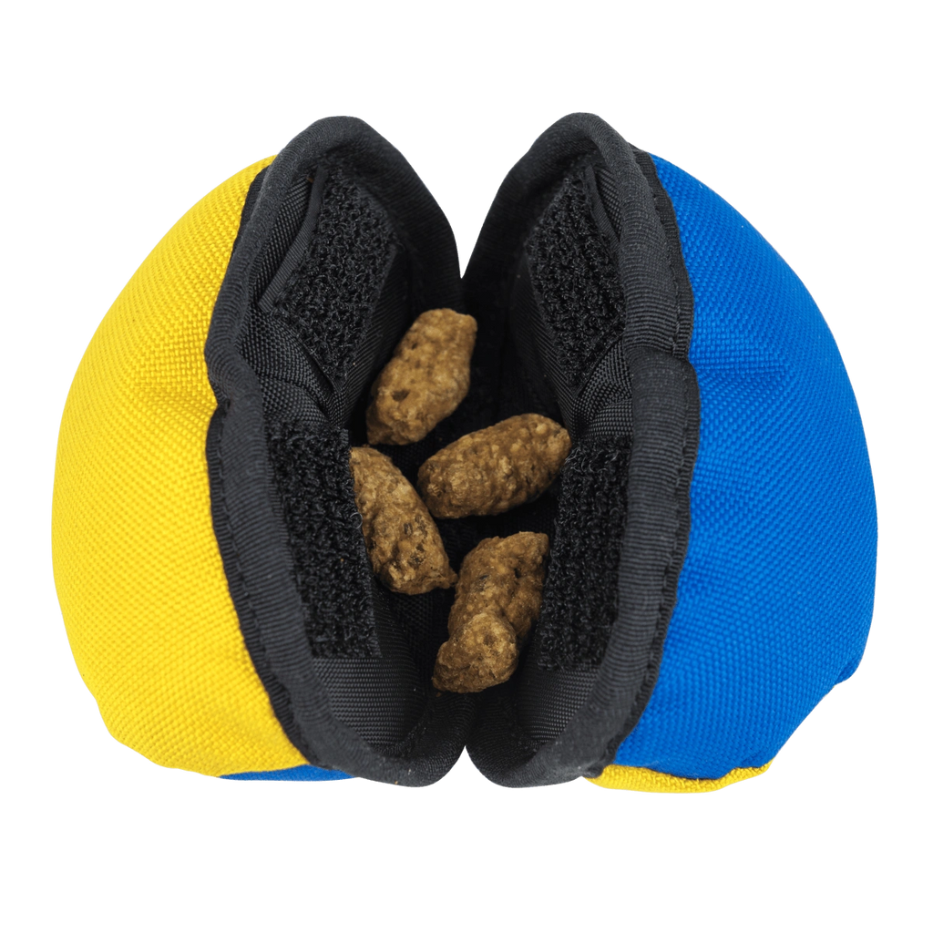 Yellow and blue clam toy opened to reveal kibble inside, designed for dogs to pry open.